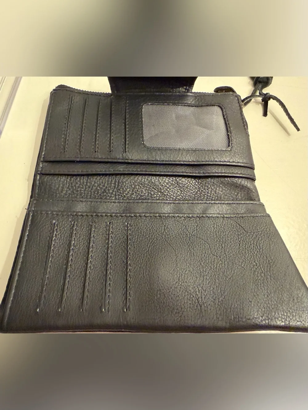 Leather wallet in black with woven flap closure.